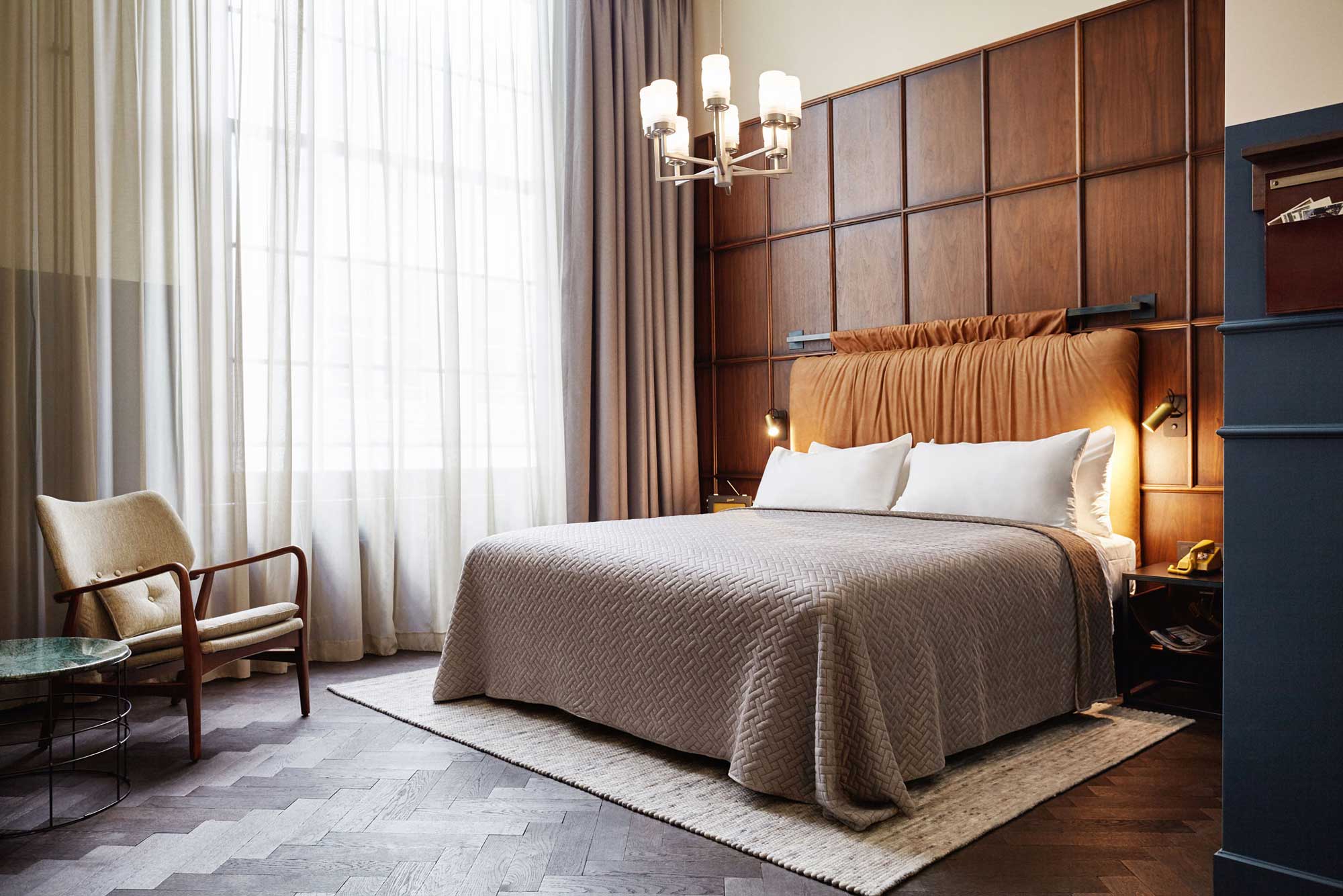 Larger room in Amsterdam hotel with wooden panelling behind the bed