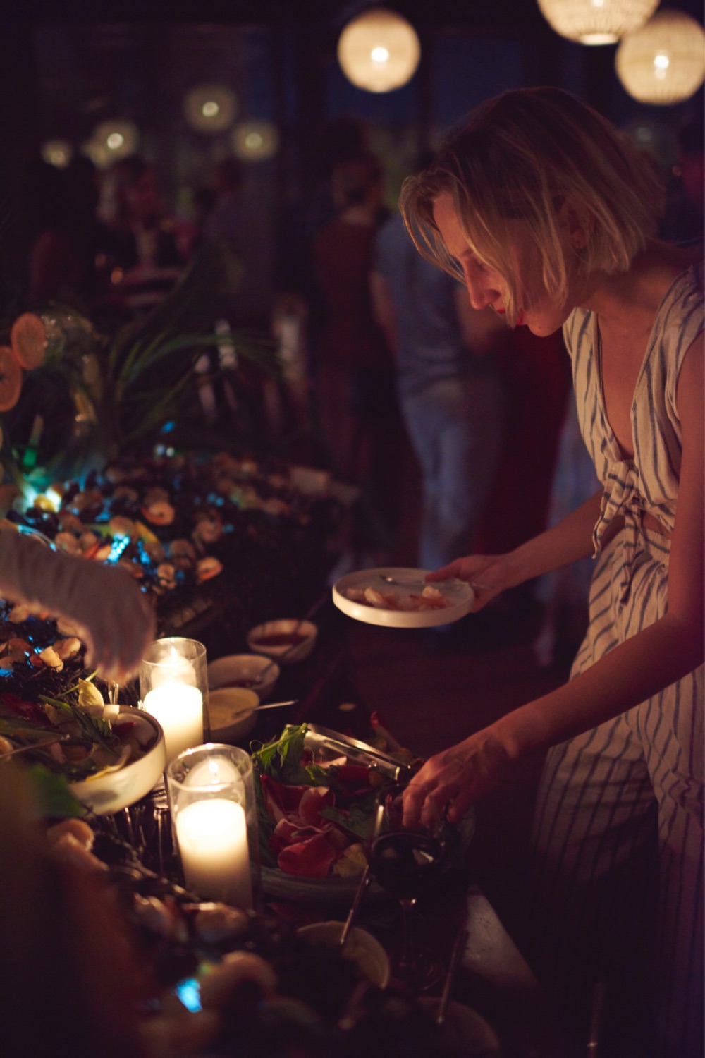 Woman getting food from a table at a party