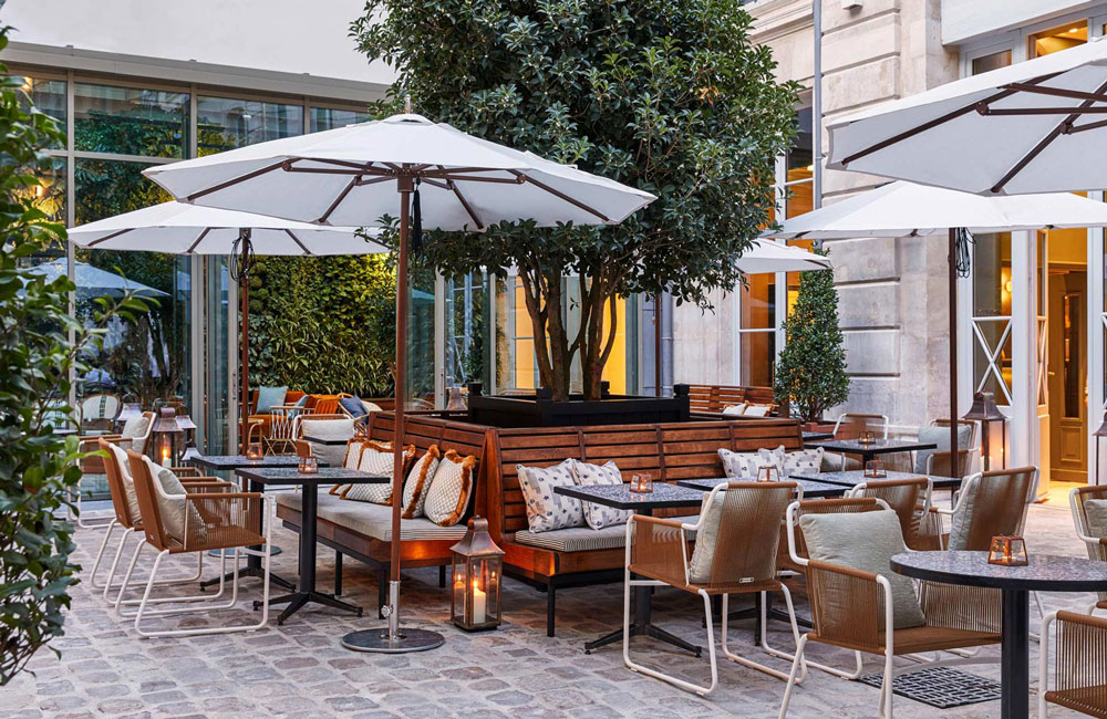 A courtyard area beside the lobby, with outdoor seating and parasols