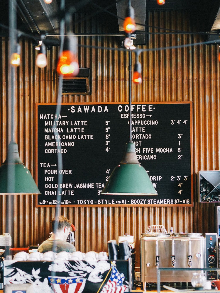 Menu board showing different hot drinks and prices in a cafe