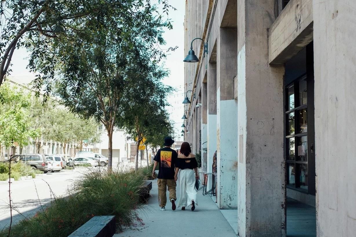 Two people walking side-by-side in The Arts District.