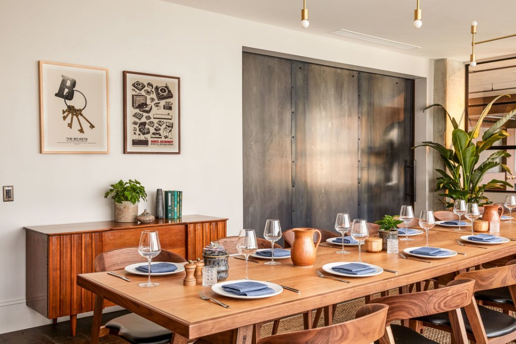 A long table set up for dining for 10 guests in a bright room