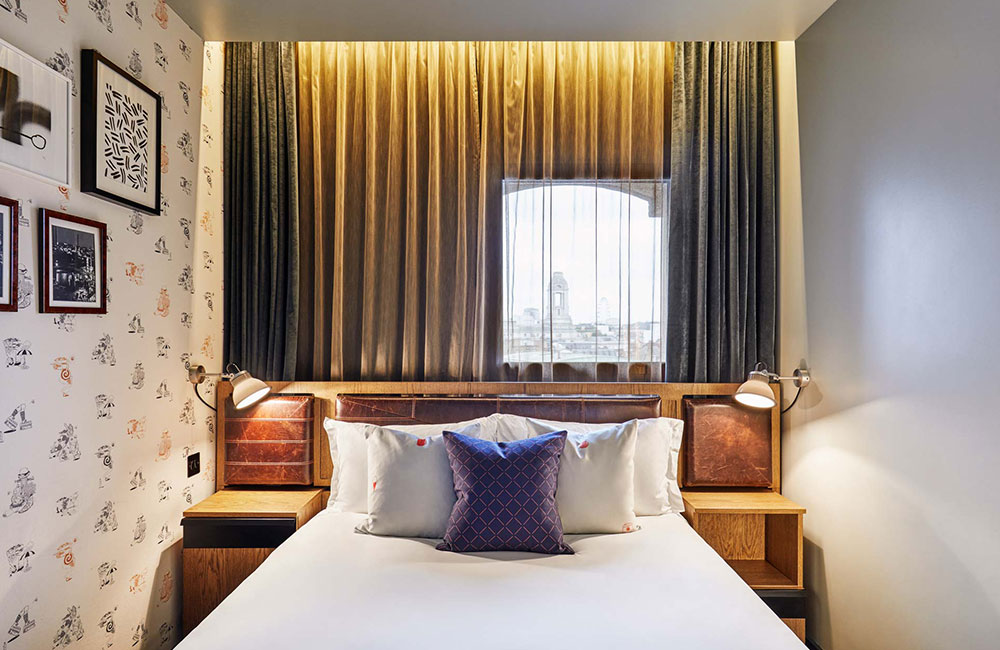 A bedroom with a small amount of space either side of the bed