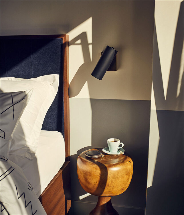 Coffee on side table beside bed in Williamsburg hotel room