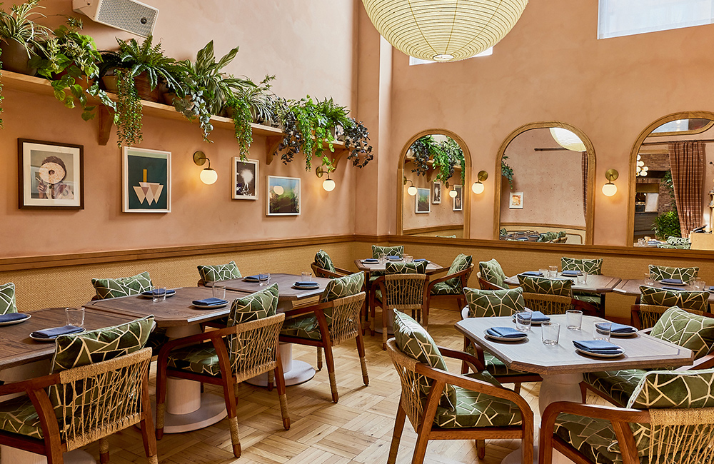 Interior of K'Far with wall art, chairs and tables for all sizes of group.