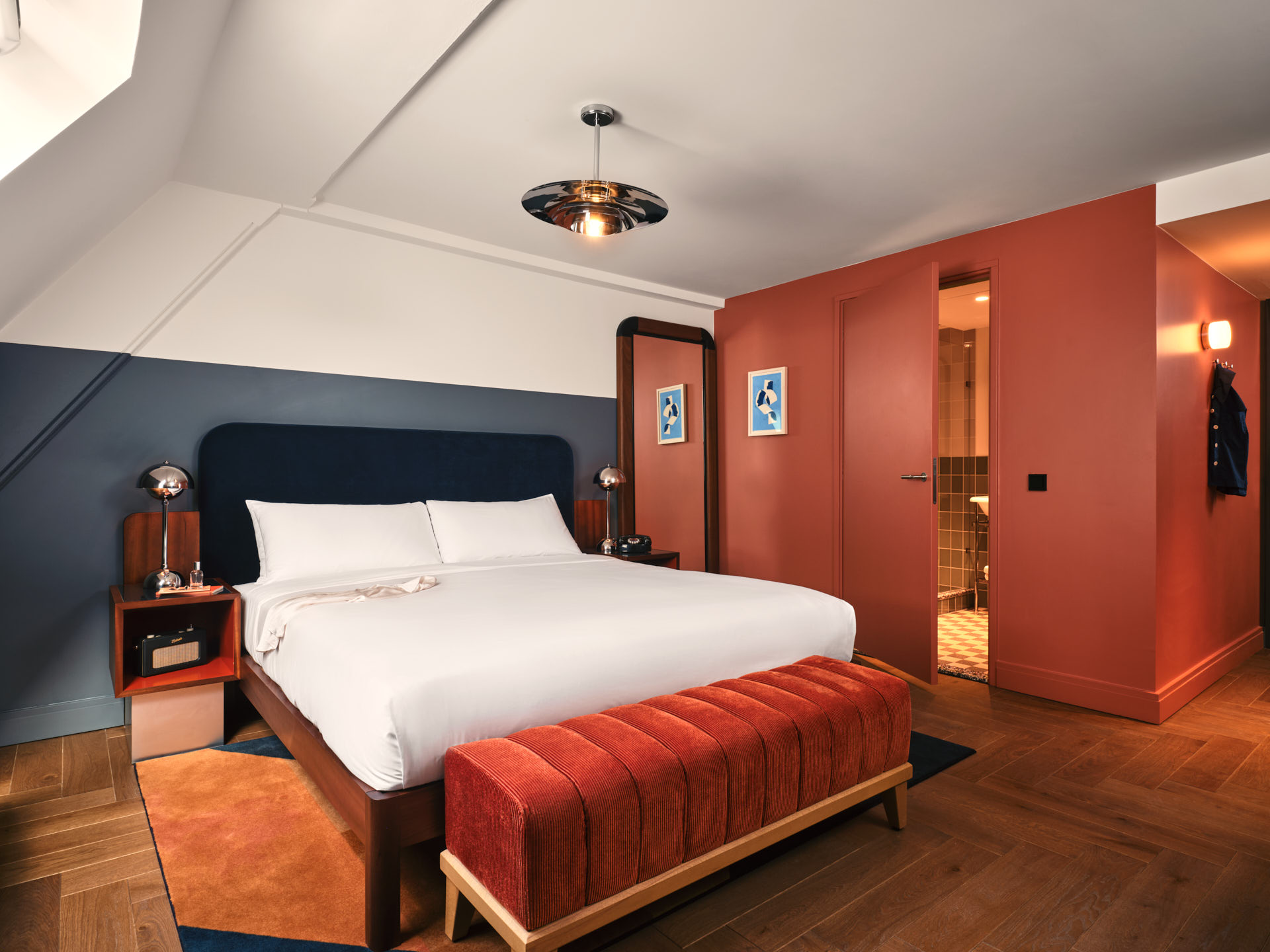 Wide shot of the Roomy bedroom showing bed, lots of floor space and storage space, and ensuite bathroom