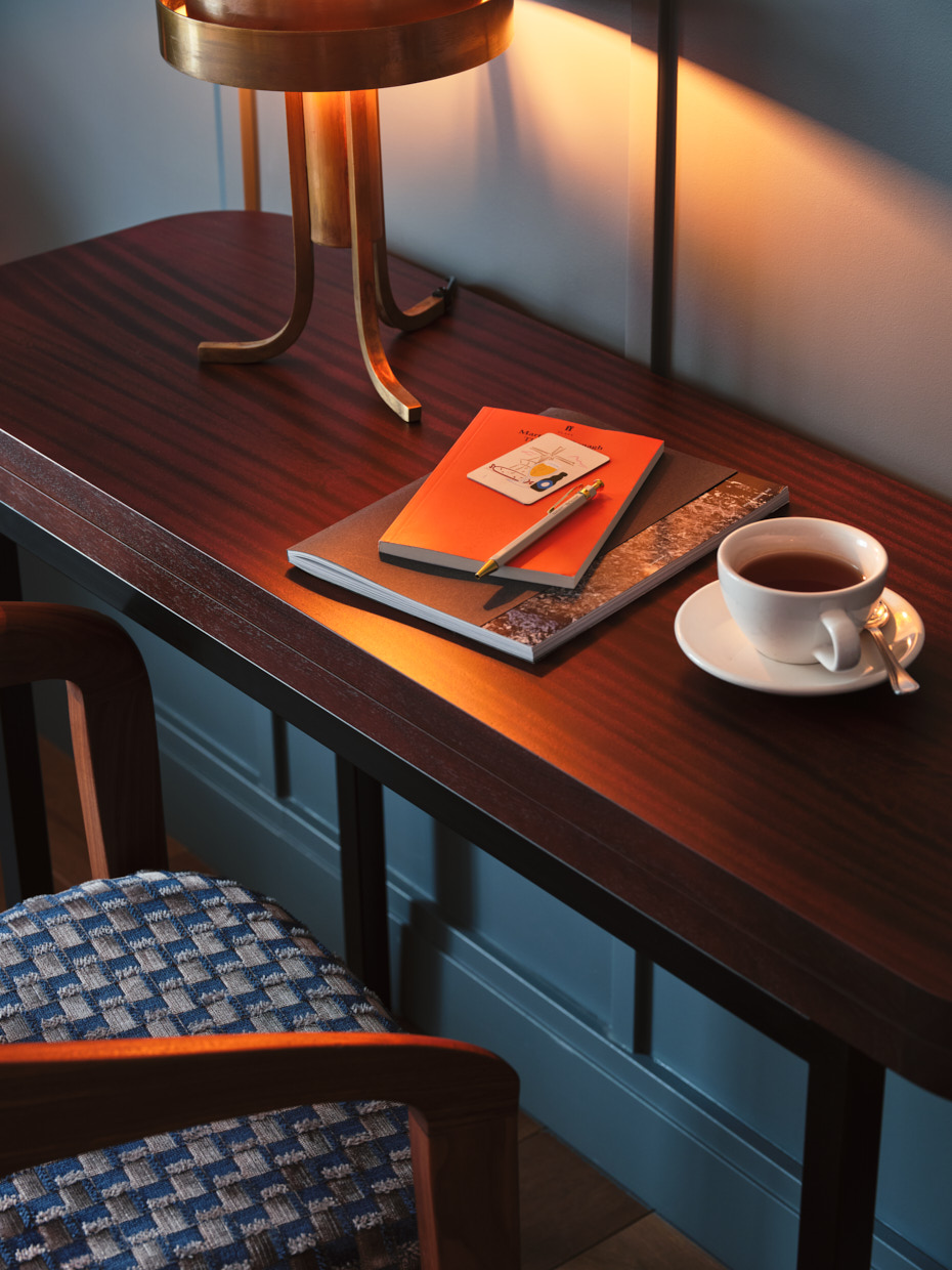 Close up of writing desk with reading lamp and cup of coffee