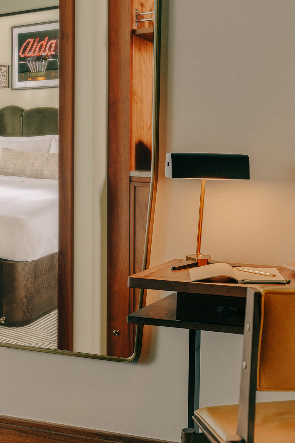 Lamp on a small table next to a rhomboidal mirror