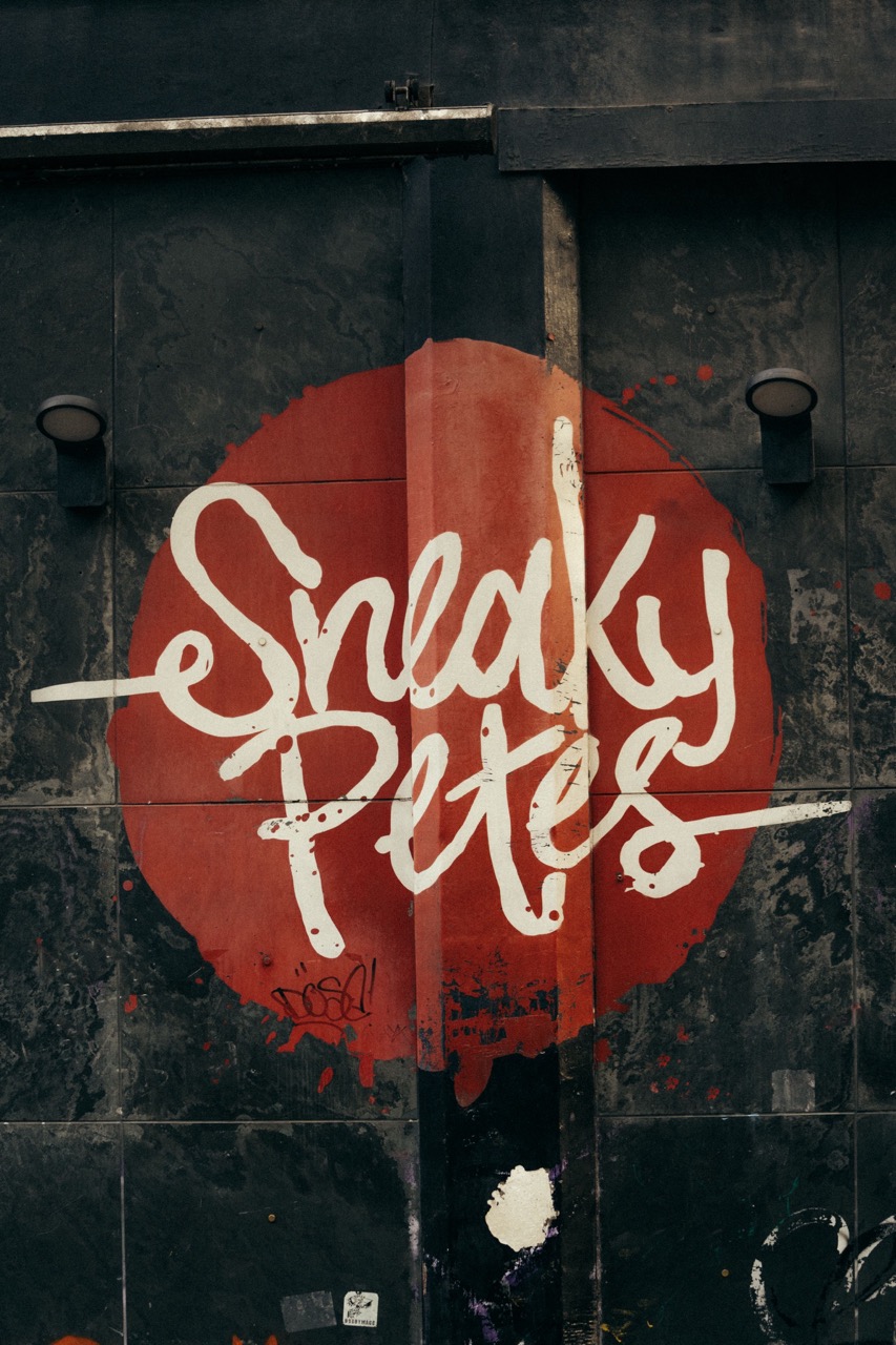 The logo of sneaky petes on a window.